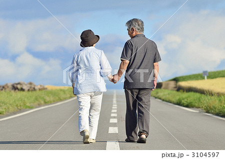 手をつないで歩く老夫婦の写真素材