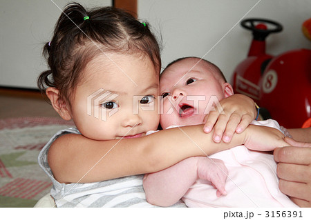 二ヶ月の赤ちゃんと２歳の女の子の姉妹の写真素材