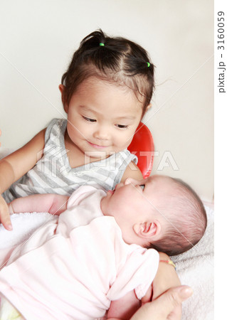 生後二ヶ月の赤ちゃんと２才の女の子の写真素材