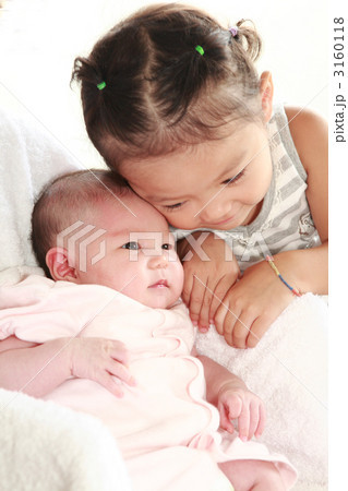 生後二ヶ月の赤ちゃんと２才の女の子の写真素材