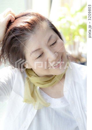 髪をかきあげるシニア女性 3209803