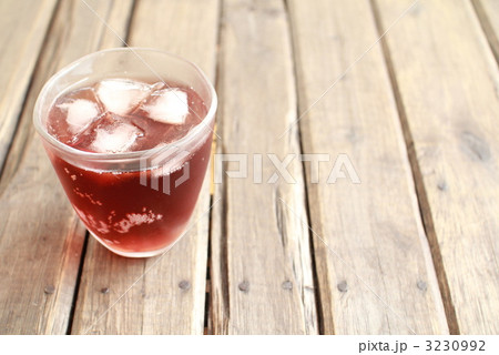 グラスに注いだ氷入りの炭酸入の葡萄ドリンク 3230992