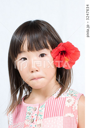 ハイビスカスの髪飾りをつける女の子の写真素材