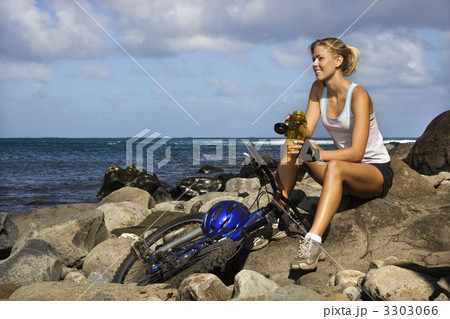 Attractive Young Woman Sitting With Bicycle on Rocky Beach Attractive Young Woman Sitting With Bicycle on Rocky Beach 3303066