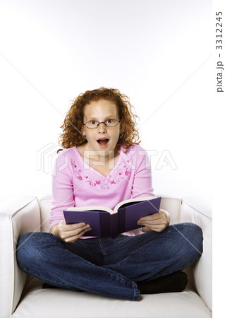 Girl reading book looking surprised. 3312245