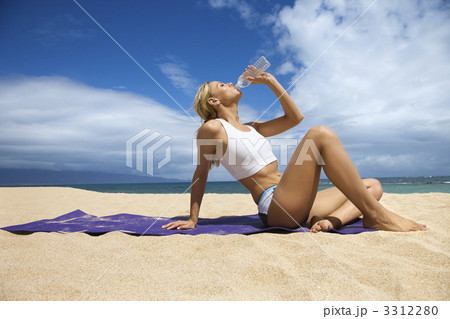 Attractive Young Woman Drinking on Beach 3312280