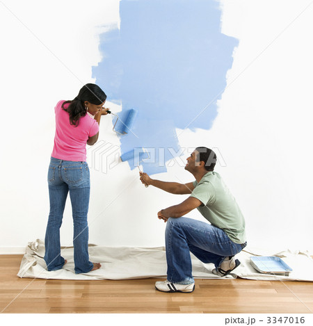 Couple painting wall blue. 3347016