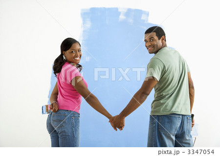 Couple next to half-painted wall. 3347054