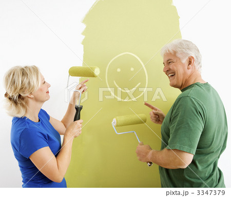 Couple laughing at smiley face painting. Couple laughing at smiley face painting. 3347379