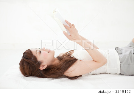 仰向けで読書をする女性の写真素材