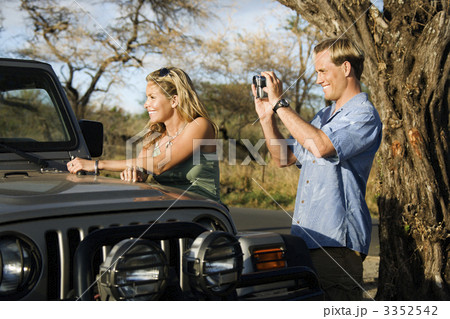 Tourist Couple Standing By Car Tourist Couple Standing By Car 3352542