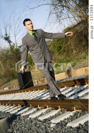 Businessman Walking on Railroad Tracks 3353684