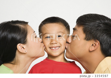Parents kissing boy. Parents kissing boy. 3354597