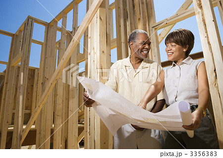 Couple Holding Building Plans on Construction Site 3356383