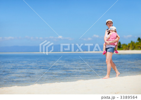 Mother with baby walking along tropical coast 3389564