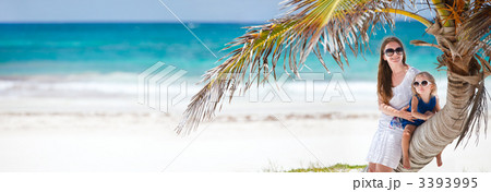Mother and daughter sitting on palm 3393995