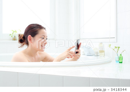 バスルームでスマートフォンを使う女の子 バスルームでスマートフォンを使う女の子 3418344