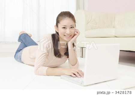 寝転んでパソコンを見る女性 3428178