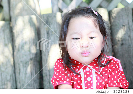 変な顔をする3才の女の子の写真素材
