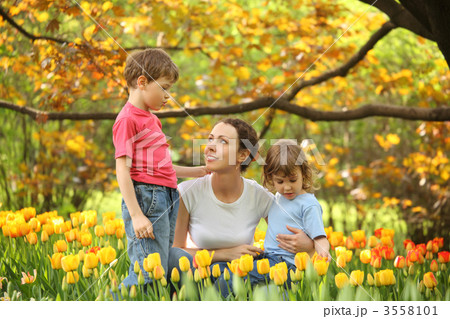 Mother with children in garden in spring among blossoming tulips Mother with children in garden in spring among blossoming tulips 3558101