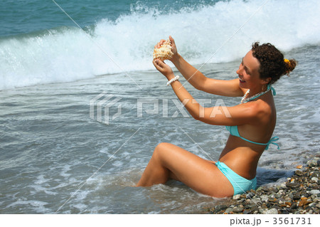 beautiful woman washes seashell in sea 3561731