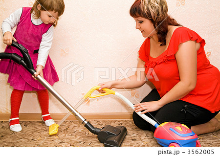 Little Girl and woman vacuum a carpet Little Girl and woman vacuum a carpet 3562005