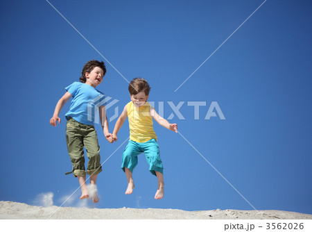 Two boys jump on sand Two boys jump on sand 3562026