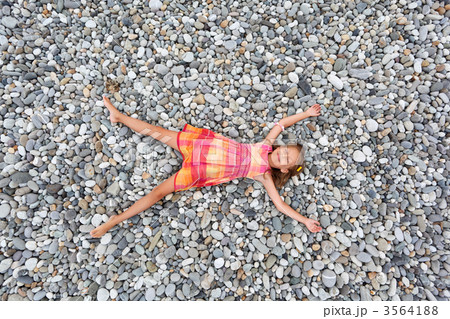 little girl lying on stones on stone seacoast 3564188