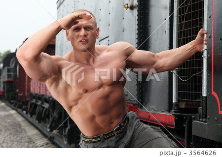 strong shirtless man keeps watch on locomotive 3564626