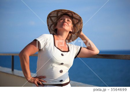 portrait of middleaged woman in hat on balcony over sea 3564699