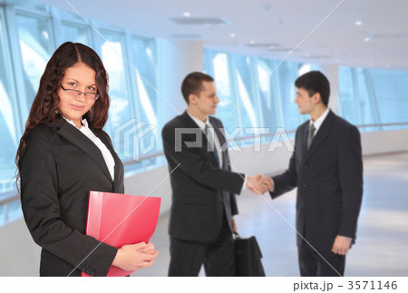 beautiful brown-haired woman with red folder and two young busin 3571146