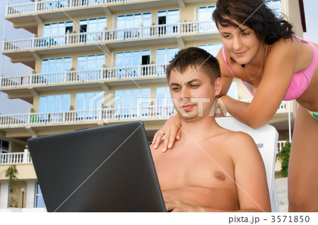 pretty woman and young man reclining on chaise lounges on beach pretty woman and young man reclining on chaise lounges on beach 3571850