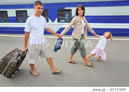 Happy family with little girl going on railway station 3572409