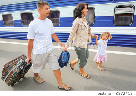 Happy family with little girl going on railway station 3572415