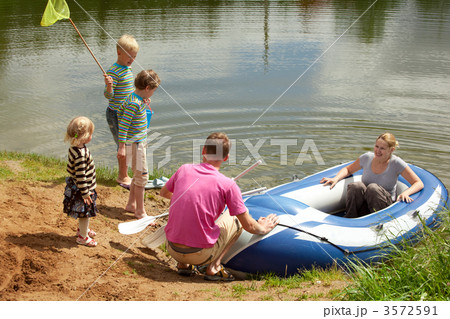 The family from five persons sits down in an inflatable boat 3572591