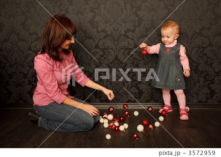 Mother and daughter consider Christmas decorations. Red and whit Mother and daughter consider Christmas decorations. Red and whit 3572959