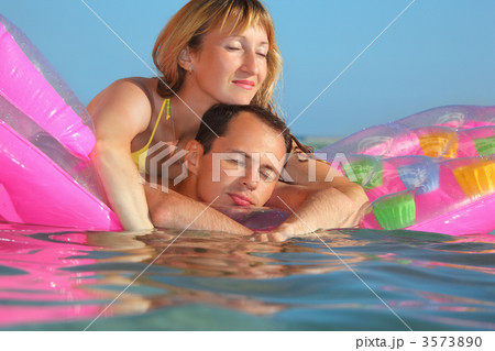 young man and nice women sleep on an Inflatable mattress in pool 3573890