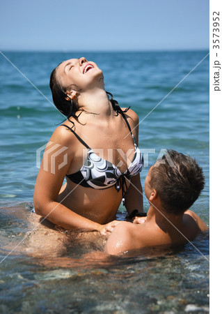Amateur Nude Beach Sex Videos - young hot woman sitting astride man in sea near... - Stock Photo [3573952]  - PIXTA