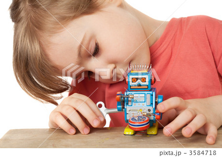 little girl in red T-shirt plays with clockwork robot isolated o little girl in red T-shirt plays with clockwork robot isolated o 3584718