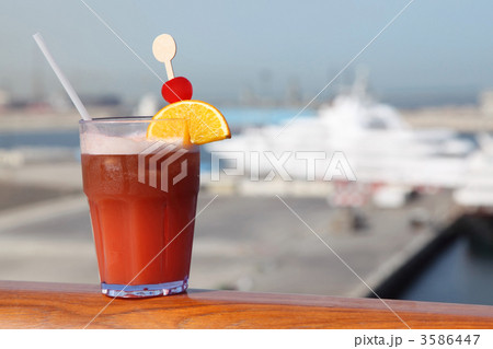 cocktail with fruits in glass on ship deck rail, port with cruis cocktail with fruits in glass on ship deck rail, port with cruis 3586447