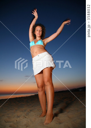 Dancing girl on shore at dusk 3588032