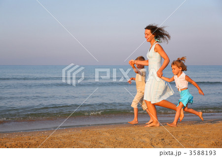 Mother with children running on edge of sea 3588193