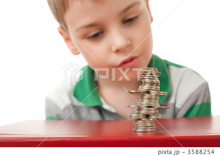 boy in striped T-shirt looking at curve pile from coins coins boy in striped T-shirt looking at curve pile from coins coins 3588254
