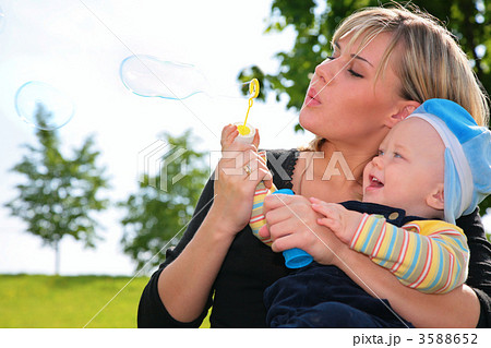 mother with a child inflates soap bubbles 3588652