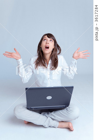 Young woman with laptop on the floor looking up Young woman with laptop on the floor looking up 3617284
