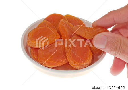 おいしそうなドライアプリコットを摘まんでいる 3694666