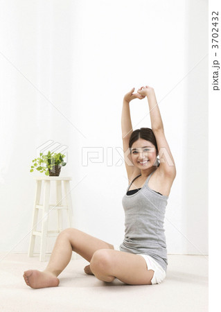 座ったまま伸びをする女性 3702432