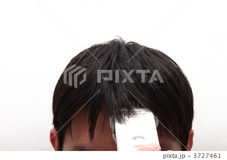 バリカンで髪を切る男性の写真素材