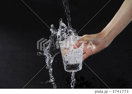 グラスから溢れる水1の写真素材