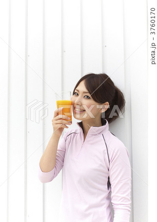 ジュースの入ったグラスを頬にあてる女性 3760170
